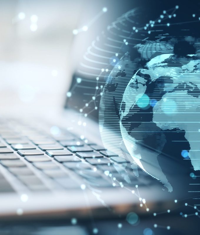 Close up of laptop with glowing money transfer globe on blurry background. Currency and stock exchange concept. Double exposure